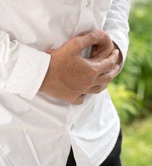 Businessman holding his stomach in pain with stomachache or indigestion