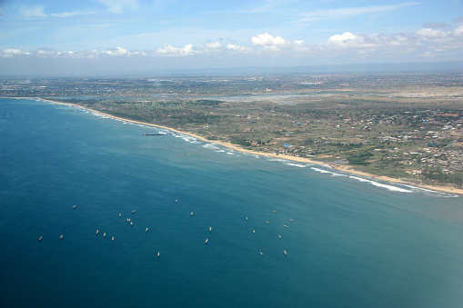 Our oceans used as ship breaking yards: All over the Ghana shore ship wreckages like this are found. Villages are built up to house the workers until the ship is completely disassembled, thereafter people leaving the village as small ghost town behind. Fisherboats (longboats) are anchored along the coast line. In the distance the urban sprawls of Accra are seen already.